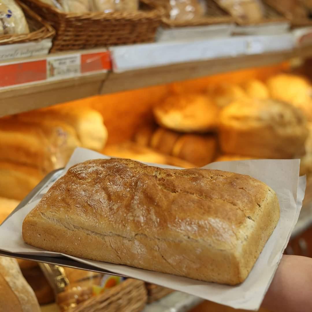 Pâine pătrată, caldă, ținută pe hârtie de copt